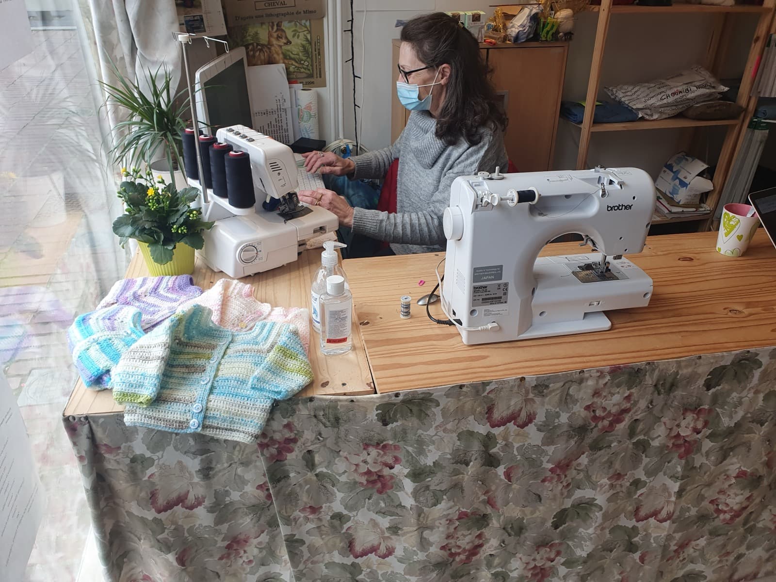Suzanne à la surjeteuse dans l'atelier de retouches
